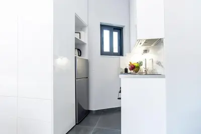 a kitchen with white walls and stainless steel appliances at Athens Syntagma Studio in Athens