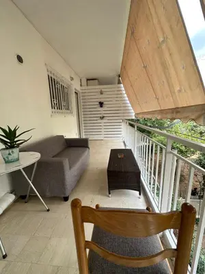 a living room with a couch and a table at Όμορφο διαμέρισμα (Αργυρούπολη) in Athens