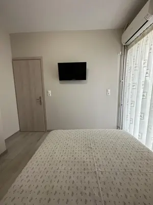 a bedroom with a bed and a television on the wall at Όμορφο διαμέρισμα (Αργυρούπολη) in Athens