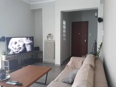 a living room with a couch and a table at AthenSunapartment top floor 5min metro in Athens