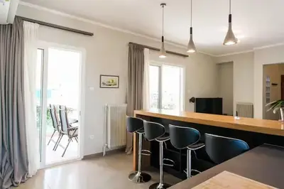 a kitchen with a bar with blue stools in it at AthenSunapartment top floor 5min metro in Athens