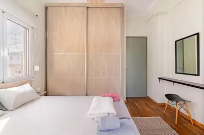 a bedroom with a large white bed and a chair at AthenSunapartment top floor 5min metro in Athens