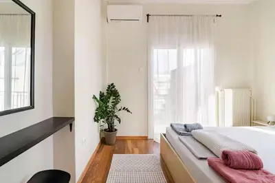 a bedroom with a large bed and a potted plant at AthenSunapartment top floor 5min metro in Athens