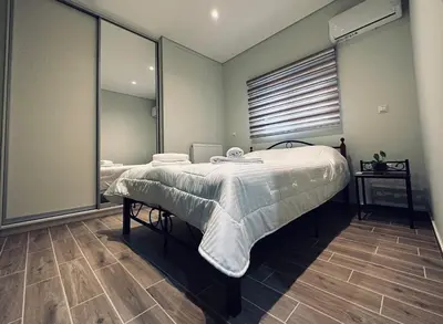 a bedroom with two beds and a large mirror at Hodos Luxury APT near ATH-Airport in Markopoulo