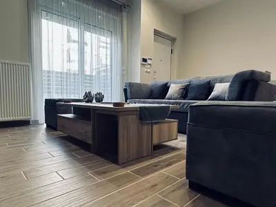 a living room with a couch and a table at Hodos Luxury APT near ATH-Airport in Markopoulo