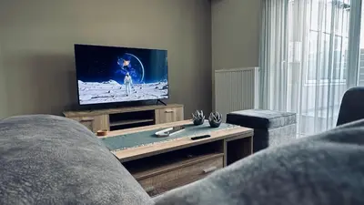 a living room with a couch and a tv at Hodos Luxury APT near ATH-Airport in Markopoulo