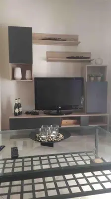 a living room with a tv and a glass table at Stella’s cottage in Athens