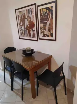 a dining room table and chairs with pictures on the wall at Stella’s cottage in Athens