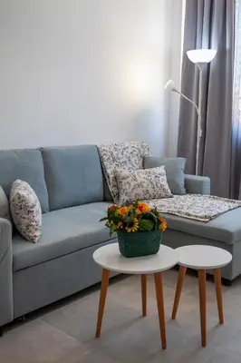 a living room with a blue couch and a table at Attalos luxury flat Psyrri square in Athens