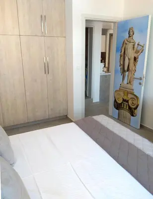 a bedroom with a statue of a man on the wall at Attalos luxury flat Psyrri square in Athens