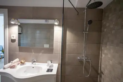 a bathroom with a sink and a shower at Attalos luxury flat Psyrri square in Athens