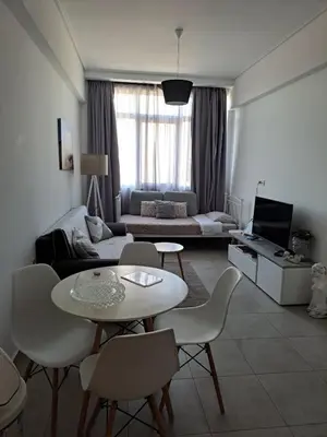 a living room with a couch and a table and chairs at Attalos luxury flat Psyrri square in Athens