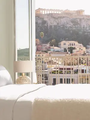 a bedroom with a bed and a view of a city at The Dolli at Acropolis, A Hotel to Live in Athens