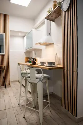 a kitchen with white cabinets and a table with chairs at Casa Tiffany Acropolis Athens by 3Cs in Athens