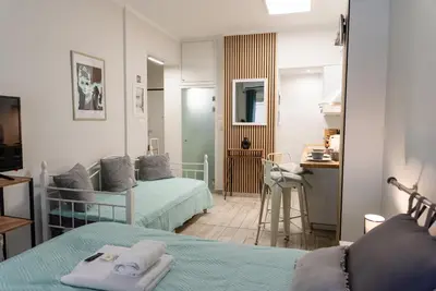 a small room with two beds and a kitchen at Casa Tiffany Acropolis Athens by 3Cs in Athens
