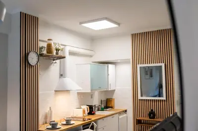 a kitchen with white cabinets and a clock on the wall at Casa Tiffany Acropolis Athens by 3Cs in Athens