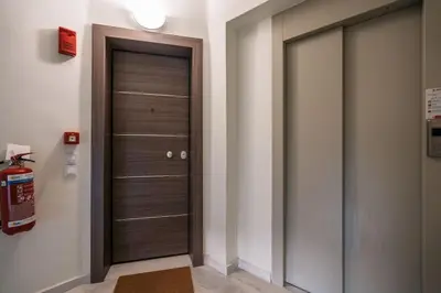 a hallway with a wooden door in a room at Duplex Acropolis View 2 Balconies in Athens