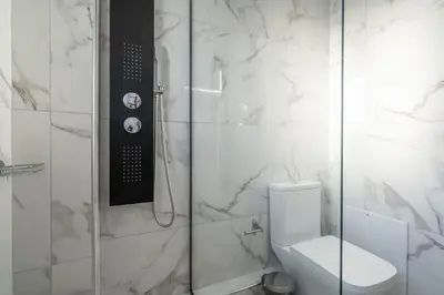a bathroom with a toilet and a glass shower at Duplex Acropolis View 2 Balconies in Athens