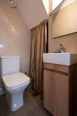 a bathroom with a white toilet and a sink at Duplex Acropolis View 2 Balconies in Athens