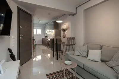 a living room with a couch and a kitchen at Duplex Acropolis View 2 Balconies in Athens