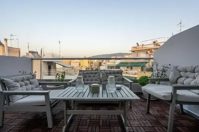 a patio with a table and chairs on a balcony at Duplex Acropolis View 2 Balconies in Athens