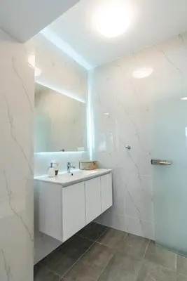 a white bathroom with a sink and a mirror at Delightful Penthouse in Athens
