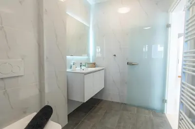 a white bathroom with a shower and a sink at Delightful Penthouse in Athens
