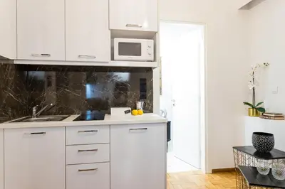 a kitchen with white cabinets and a microwave at Center of Athens: Iris cozy apartment in Athens