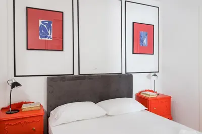 a bedroom with a bed with four pictures on the wall at Center of Athens: Iris cozy apartment in Athens