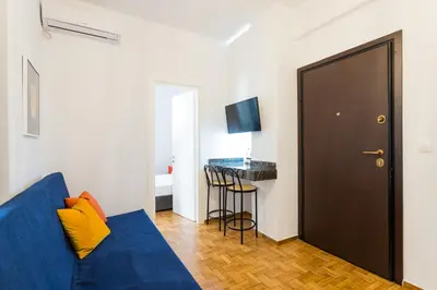 a living room with a blue couch and a table at Center of Athens: Iris cozy apartment in Athens
