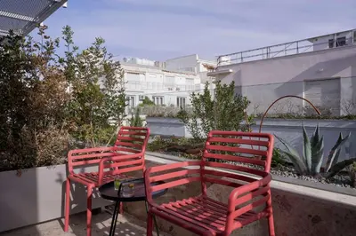 two red chairs and a table on a balcony at The Social Athens Hotel, a member of Radisson Individuals in Athens