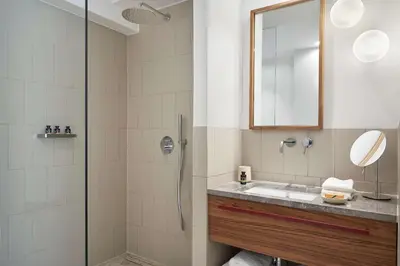 a bathroom with a shower and a sink and a mirror at The Social Athens Hotel, a member of Radisson Individuals in Athens