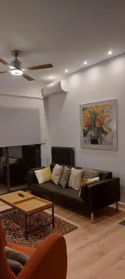 a living room with a couch and a ceiling fan at Charming Apartment in Chalandri in Athens
