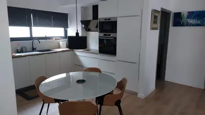 a white kitchen with a table and chairs in it at Charming Apartment in Chalandri in Athens