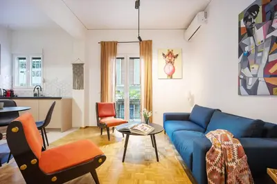 a living room with a blue couch and a table at Stylish Apartment in Thissio l Dedicated Workspace in Athens