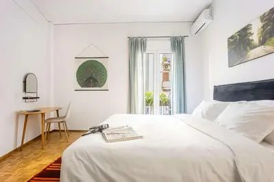a white bedroom with a bed and a table at Stylish Apartment in Thissio l Dedicated Workspace in Athens