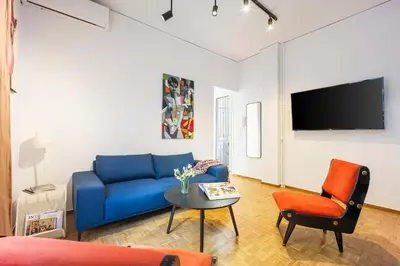 a living room with a blue couch and a table at Stylish Apartment in Thissio l Dedicated Workspace in Athens
