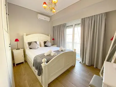 a bedroom with a white bed with two towels on it at Luxury Vacation by LV in Athens