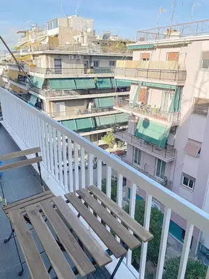 a balcony with a wooden bench and a building at Luxury Vacation by LV in Athens