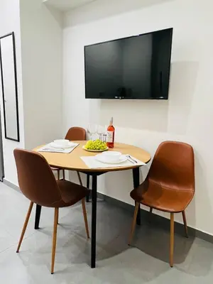 a table with two chairs and a television on a wall at Likourgou Suite Dialog Number 1 VIPGreece in Athens