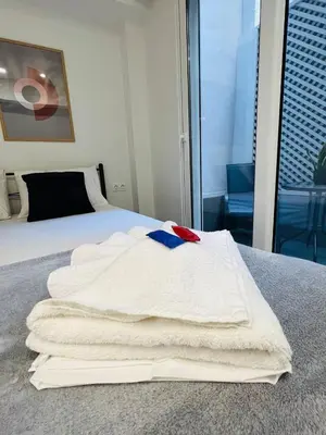 a pile of towels sitting on top of a bed at Likourgou Suite Dialog Number 1 VIPGreece in Athens