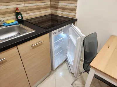 a small refrigerator with its door open in a kitchen at Menelaou Cozy Apartment VIPGreece in Athens