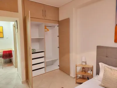 a bedroom with a closet and a bed and a table at Menelaou Cozy Apartment VIPGreece in Athens