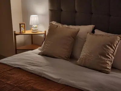 a bed with white sheets and pillows and a lamp at Menelaou Cozy Apartment VIPGreece in Athens