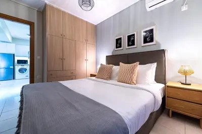 a bedroom with a large bed and a bathroom at Phaedrus Living Luxury Flat Ampelokipoi in Athens