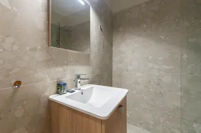 a bathroom with a white sink and a mirror at Phaedrus Living Luxury Flat Ampelokipoi in Athens
