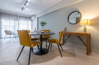 a dining room with a table and chairs and a mirror at Phaedrus Living Luxury Flat Ampelokipoi in Athens
