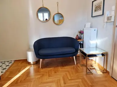 a blue chair in a living room with a table at Simple & Noble in Athens