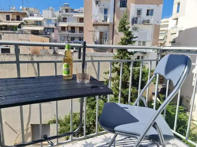 a bottle of beer sitting on a table on a balcony at Simple & Noble in Athens