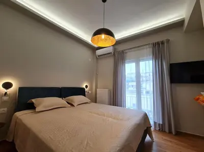a bedroom with a bed and a large window at Simple & Noble in Athens